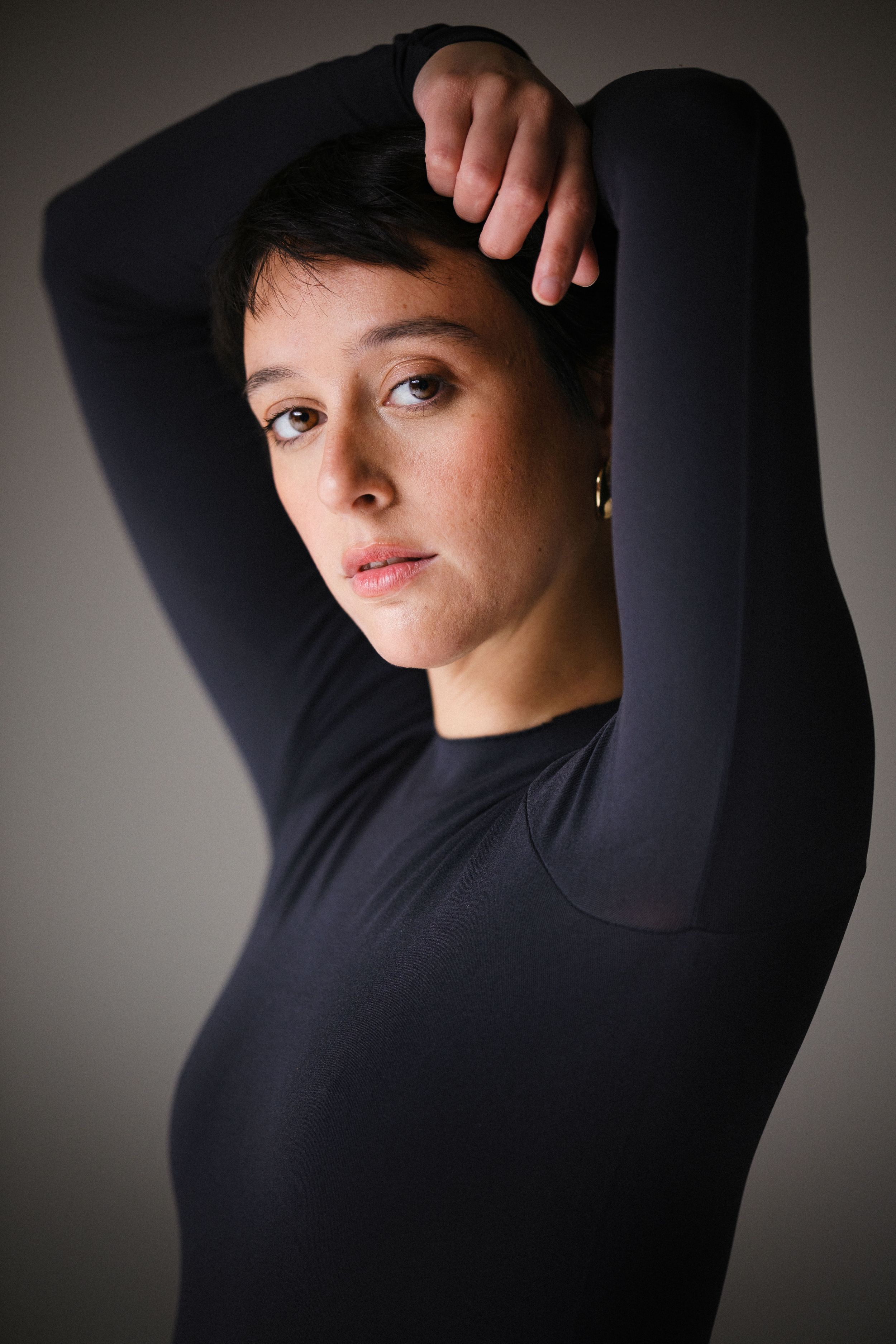 Artistic portrait sequence with raised arms and dramatic shadows.