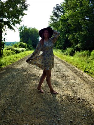 Footsteps along a sunlit dirt path bordered by summer greenery.