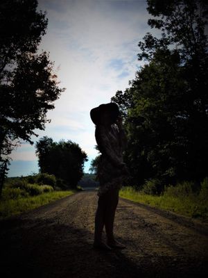Silhouetted figures on a dirt path during sunset.
