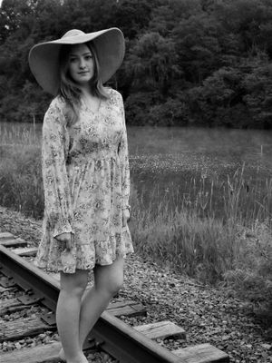 Rustic railroad tracks cutting through tall grass and wildflowers.