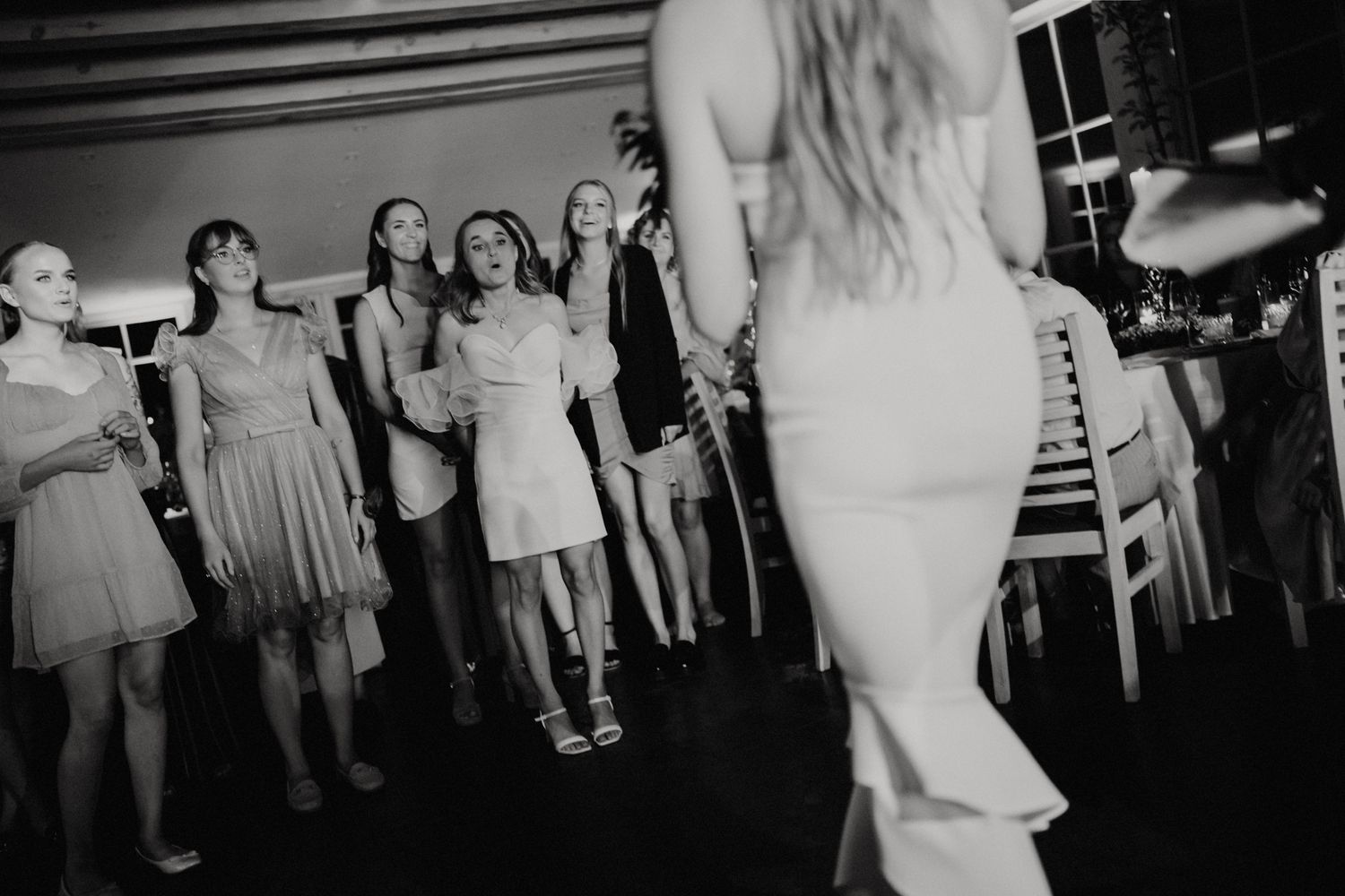 Wedding guests dancing and mingling at an indoor reception venue.