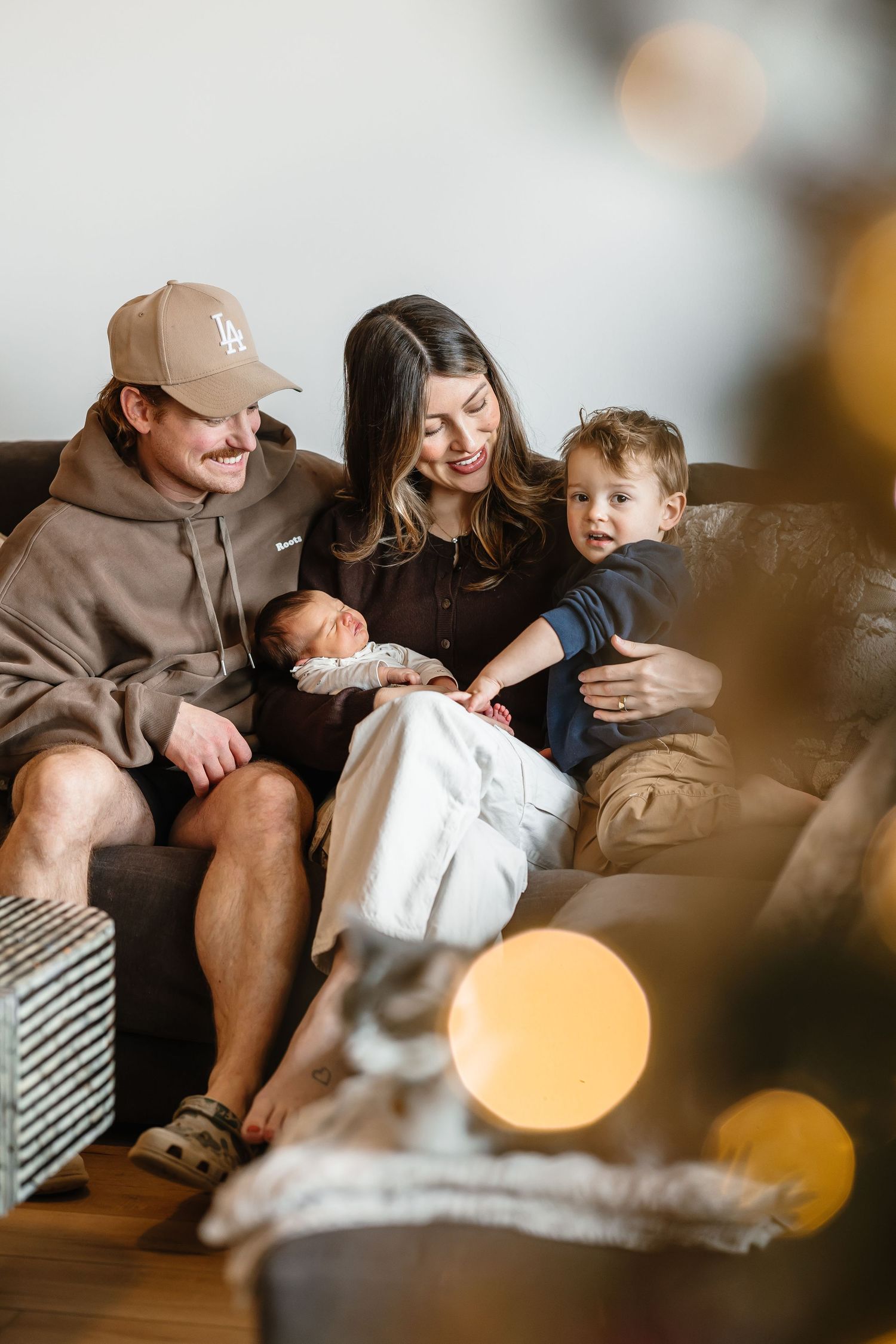 Cozy lifestyle newborn photoshoot in living room with bokeh lights in Kelowna, BC