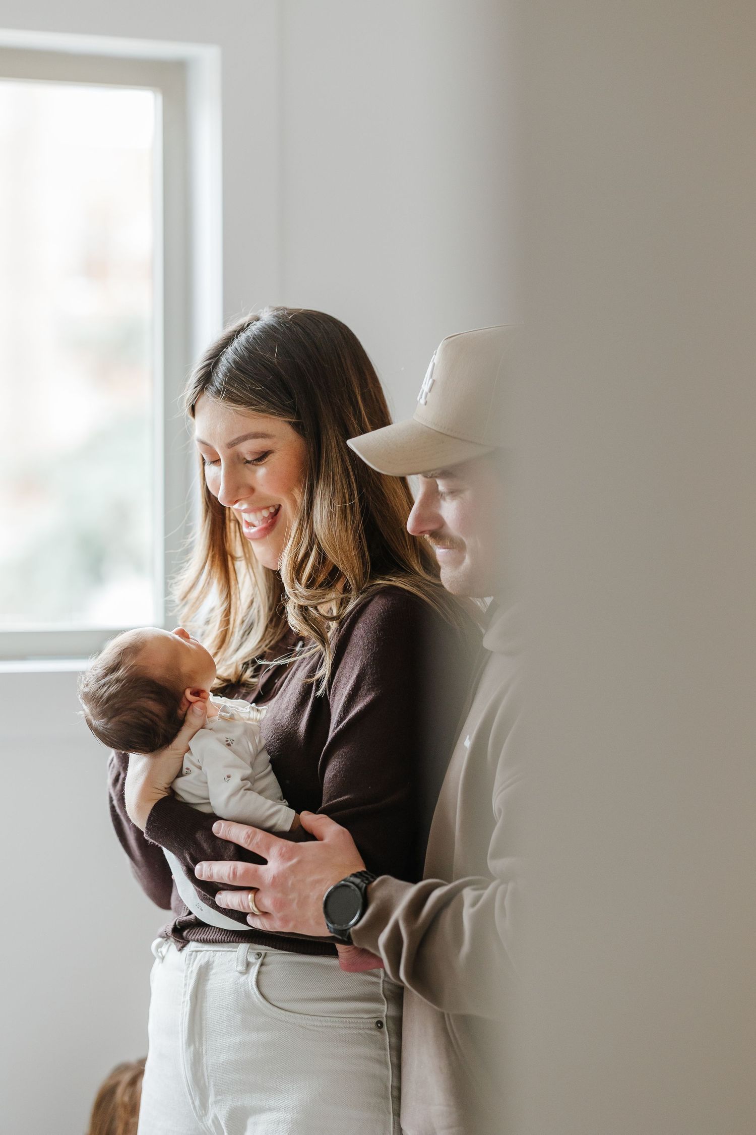 Candid lifestyle photography session for a newborn light and airy photoshoot with baby and parents in a Kelowna, BC home.