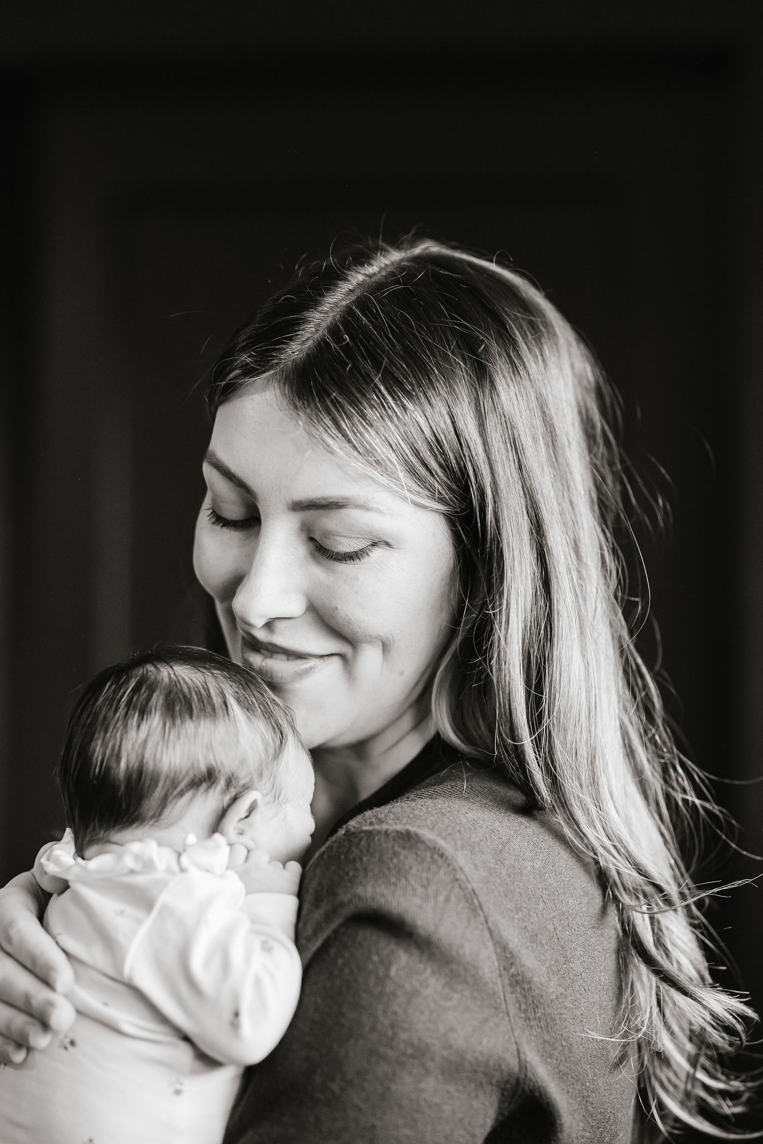 Black and white photo series showing intimate moments of maternal affection and bonding during a newborn lifestyle photoshoot in Kelowna, BC