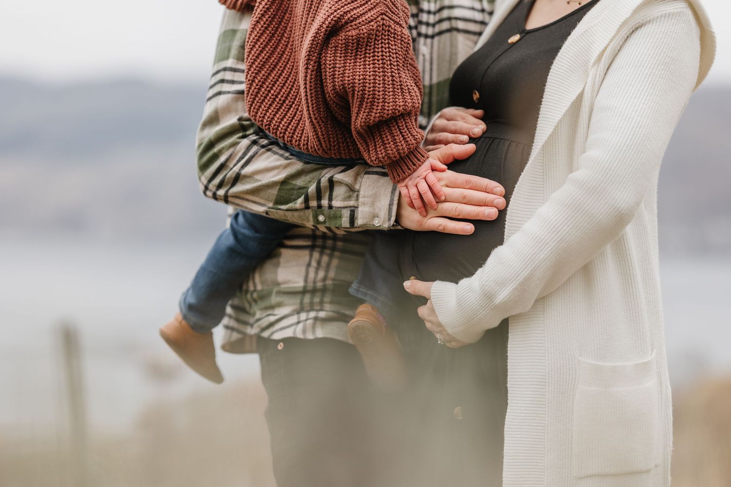 couples close up shot of pregnant belly during a maternity session in Kelowna bc overlooking okanagan lake