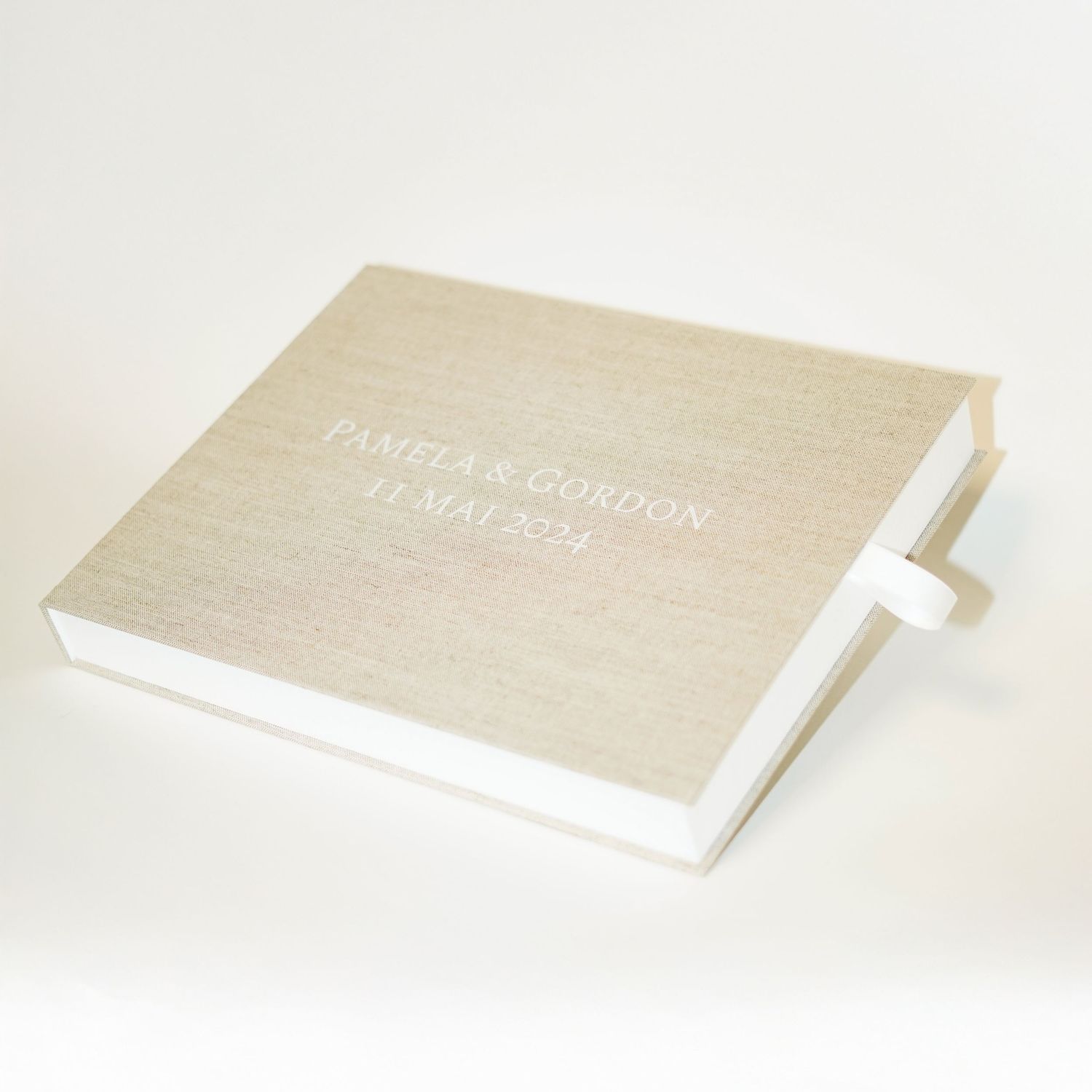 Elegant linen-covered photo album or wedding book with white binding.