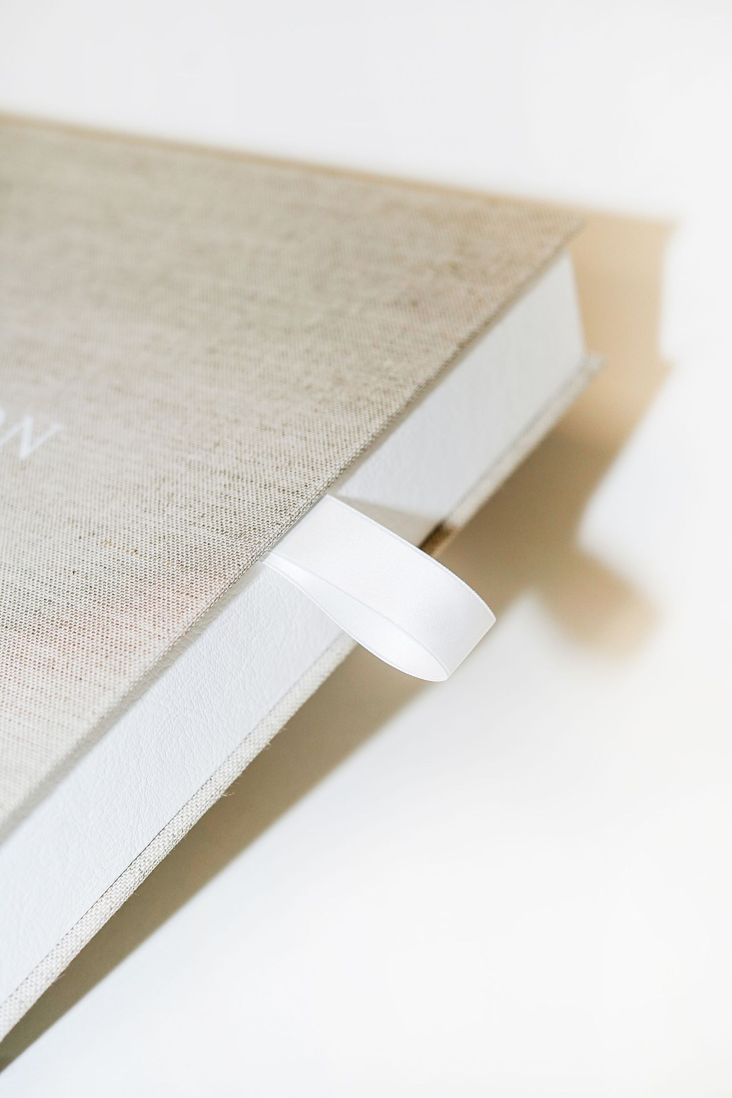 Close-up view of a linen-bound book with a white bookmark tab.