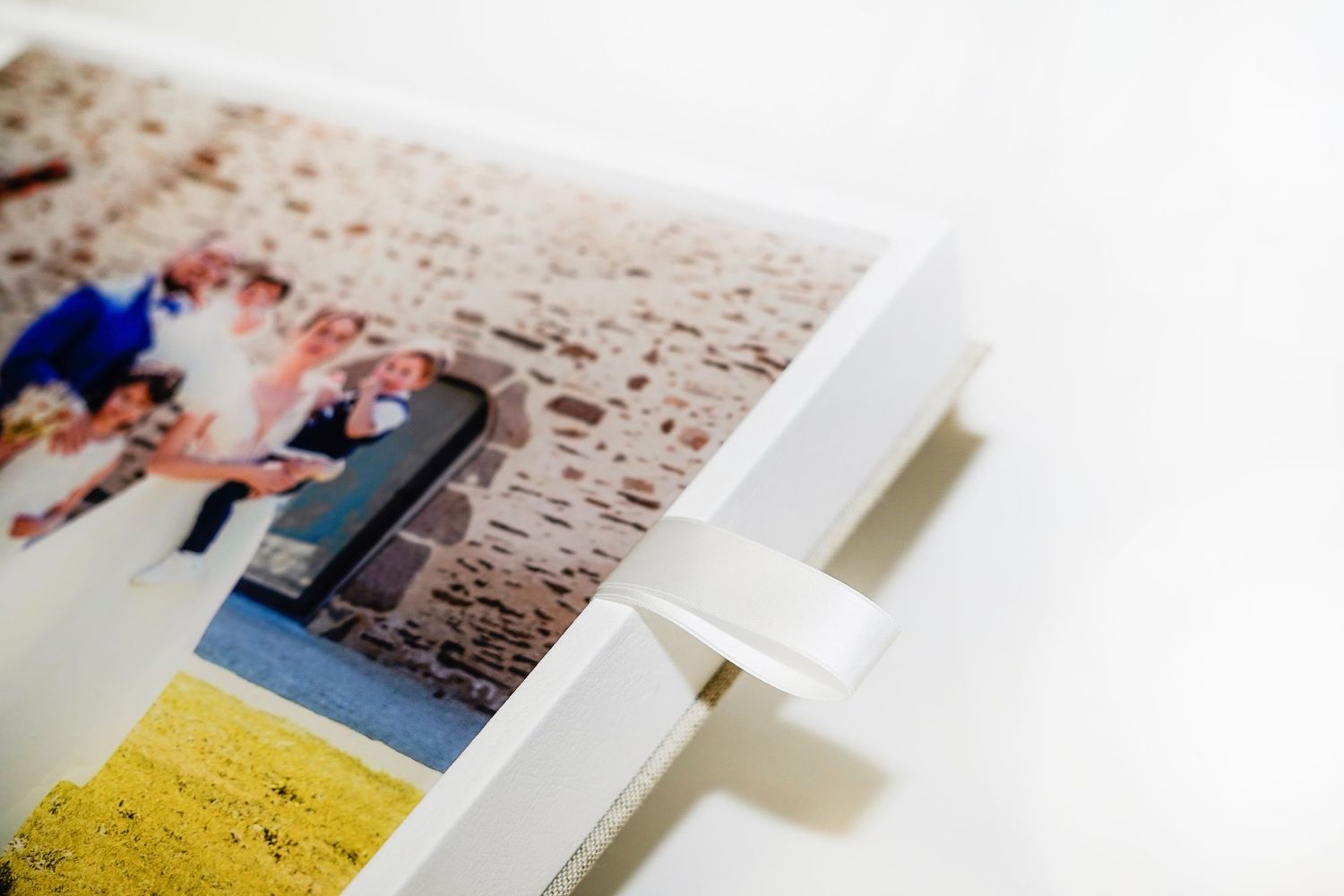 Close-up detail of a mounted wedding photograph with white corner tabs.