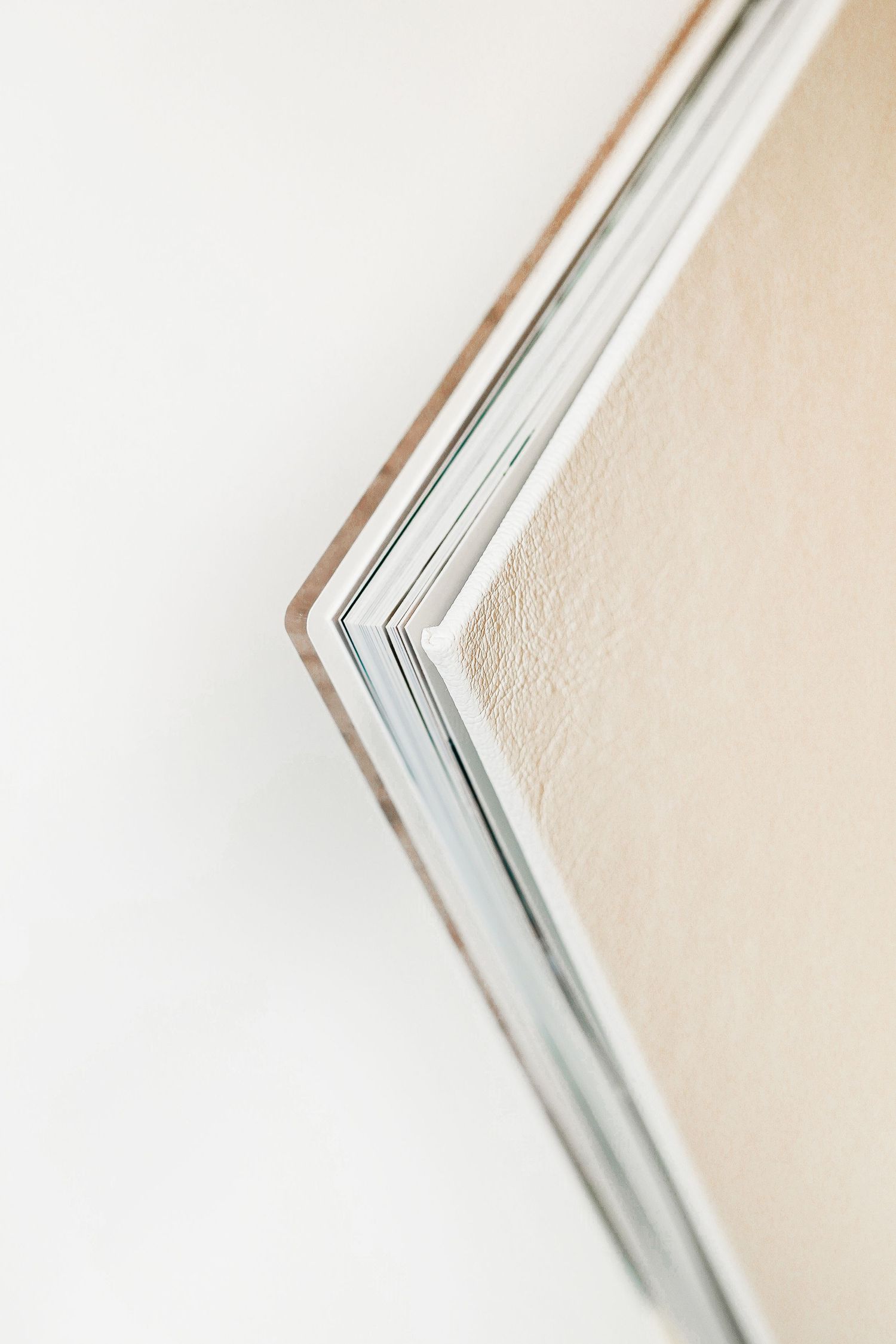 Detailed corner view of layered white photo album pages showing textural edges.