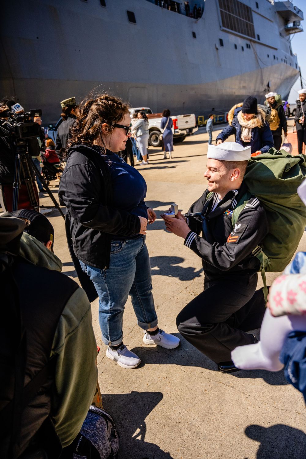 Special moment captured during military homecoming ceremony near naval ship.