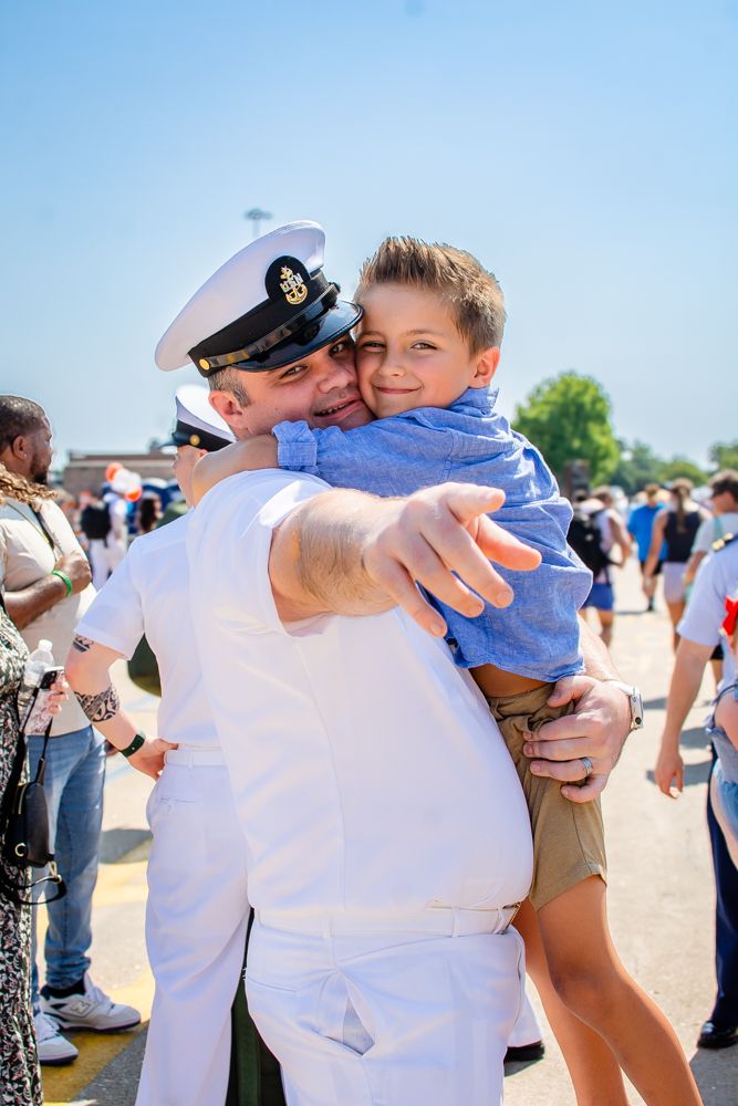 Joyful embrace between service member and child during military homecoming.