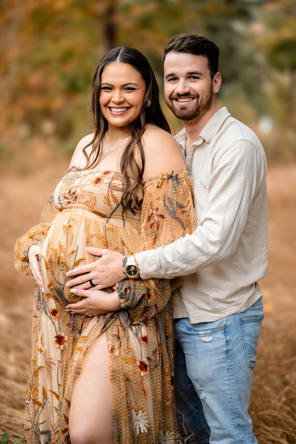 Autumn maternity photo captures a tender moment between couple in golden natural light.