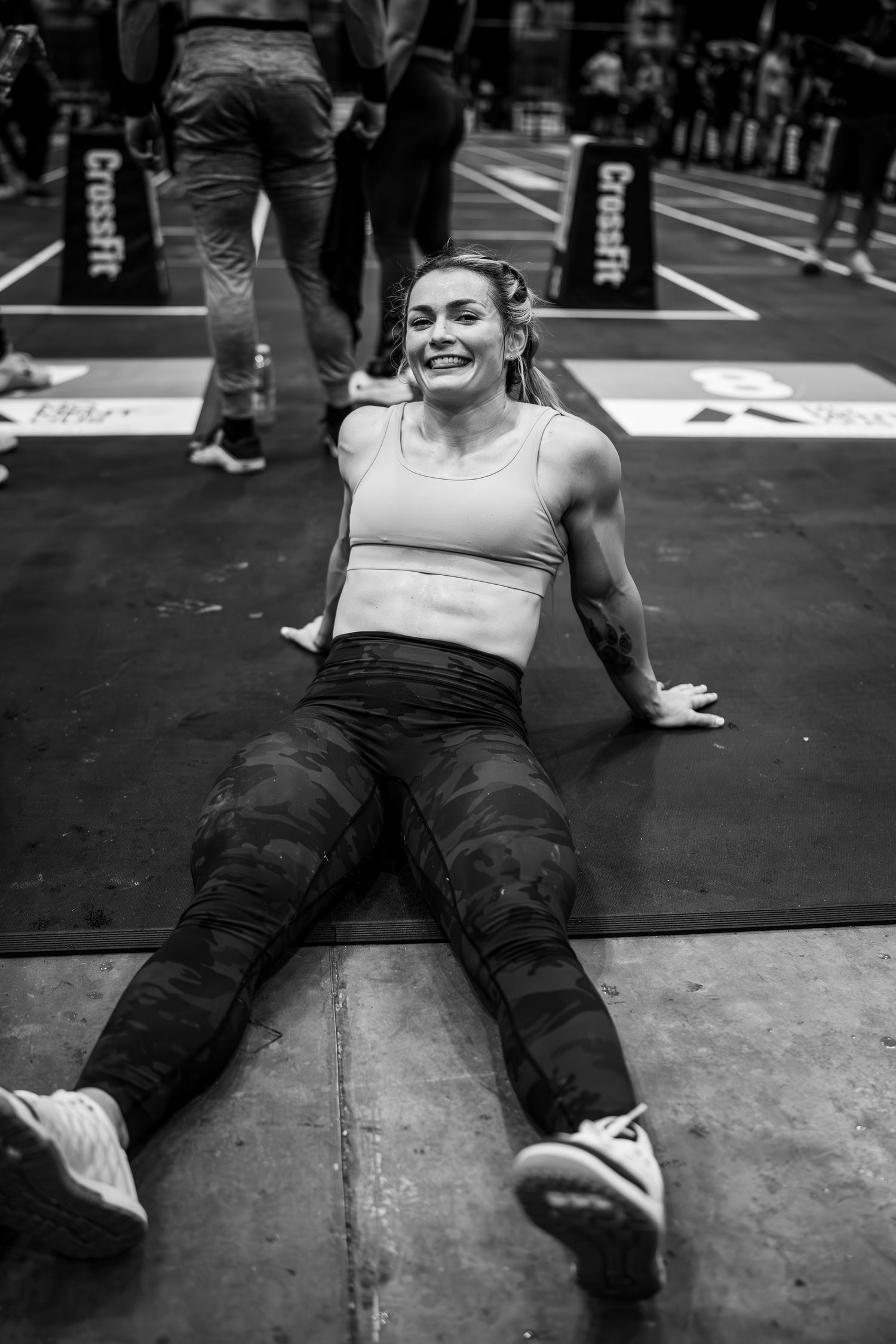 An athlete lies exhausted on a gym floor after an intense CrossFit workout.