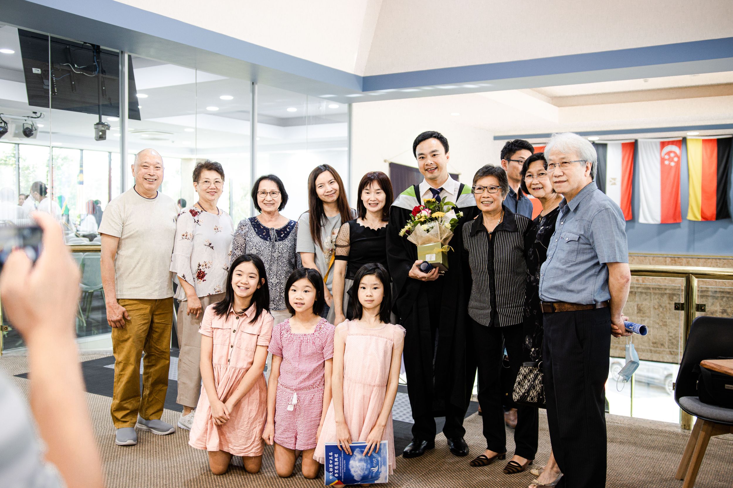 Family gathering in retail store space for celebration photo.