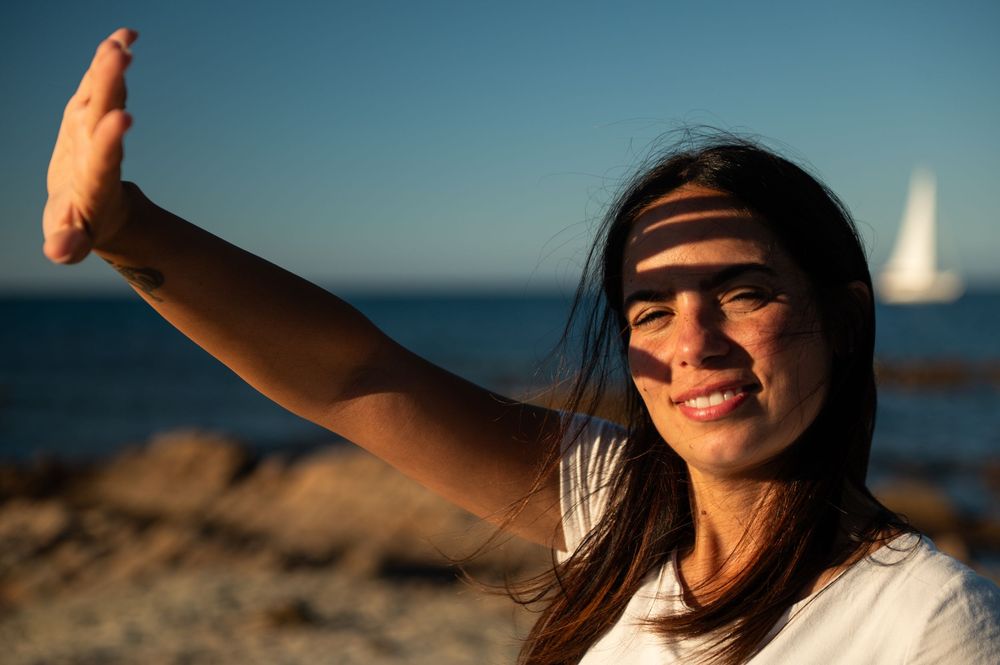 Candid seaside portraits with natural sunlight and ocean backdrop.