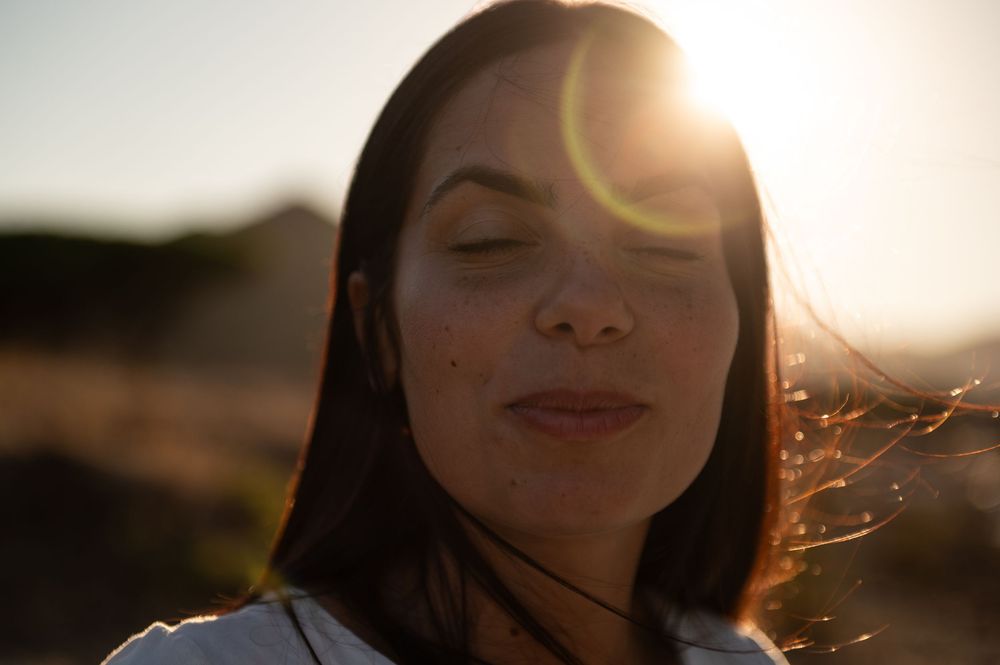Silhouette portraits against bright sunlight creating a warm backlit glow.