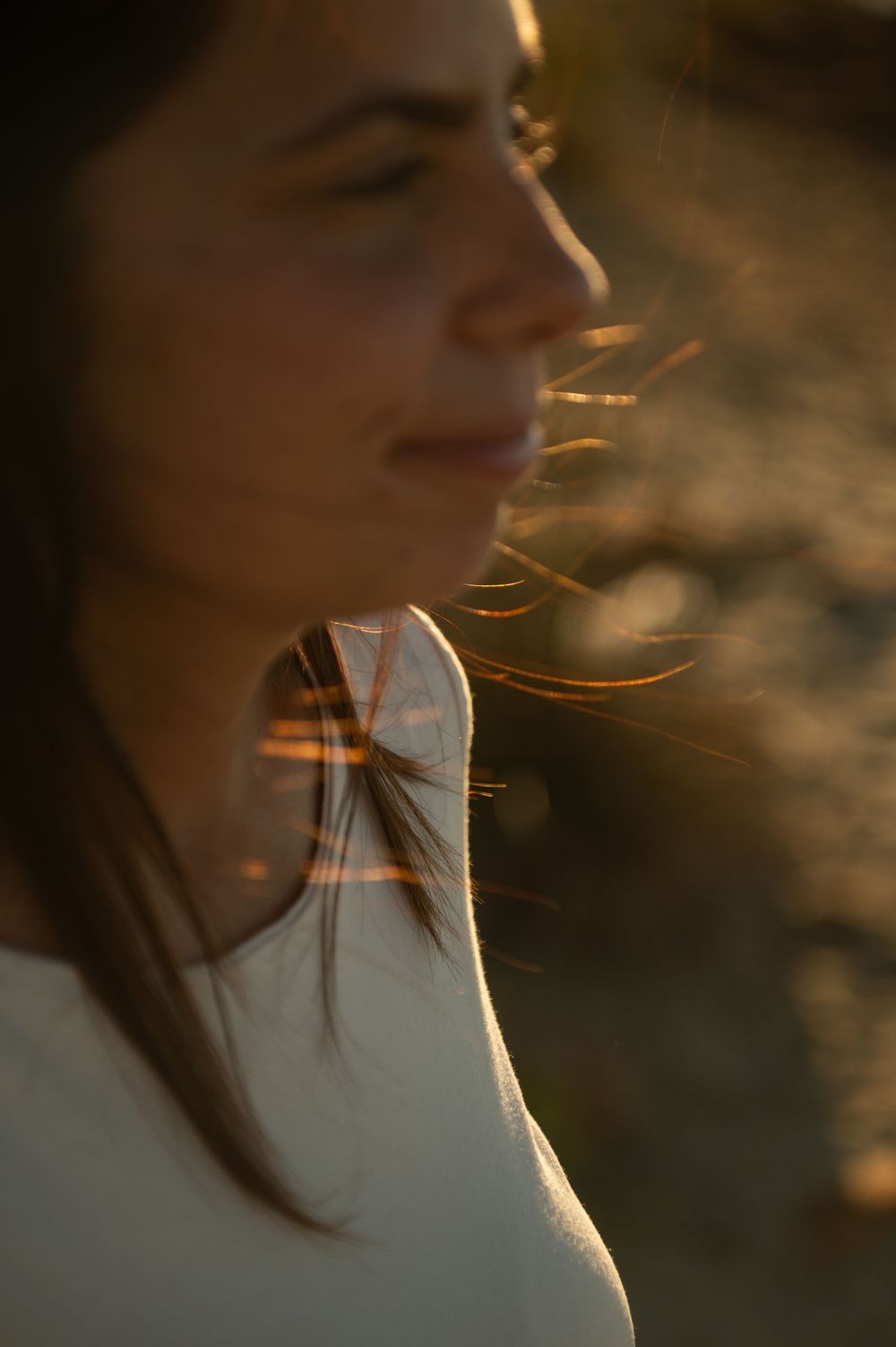 Artistic close-up shots with hair blowing in the wind at golden hour.