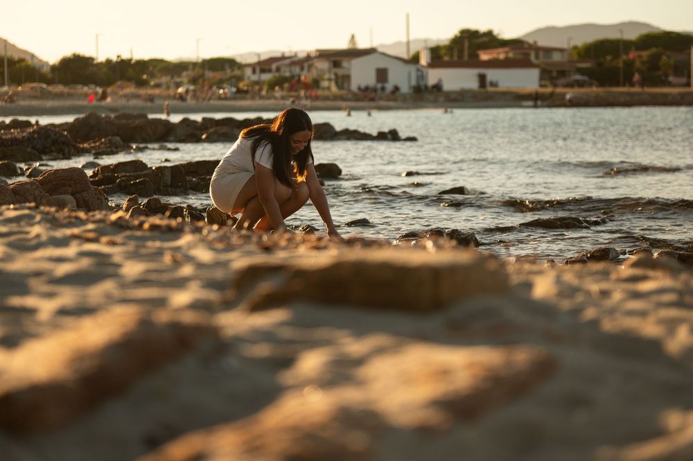 Scenic beach landscape with rocky coastline at golden hour.