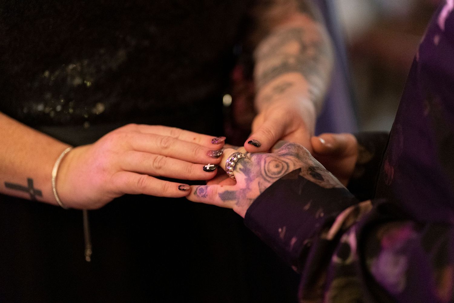 Close-up of hands drawing intricate henna designs in candlelight.