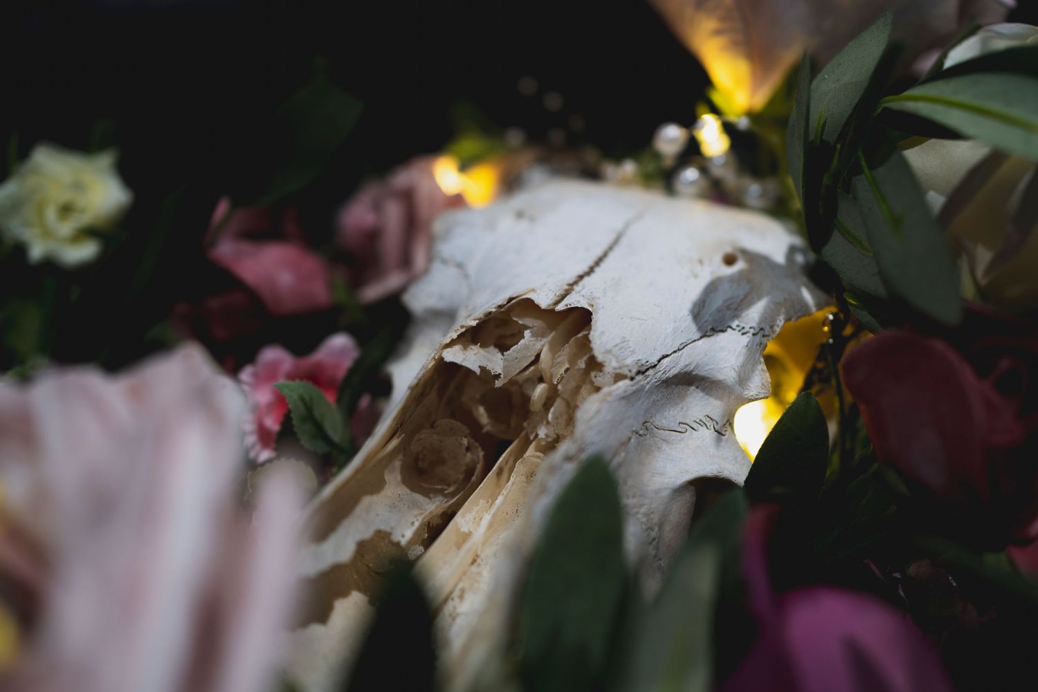 Artistic macro shot of wedding floral arrangements with mixed flowers in moody lighting.