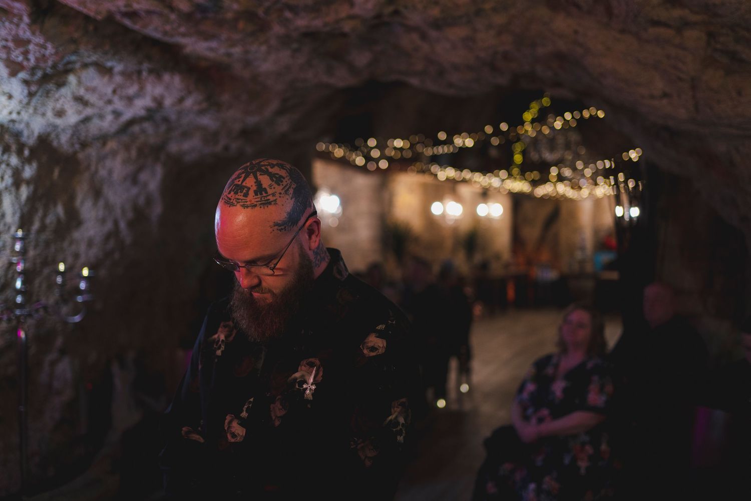 Atmospheric underground cave venue decorated with string lights and stone walls.