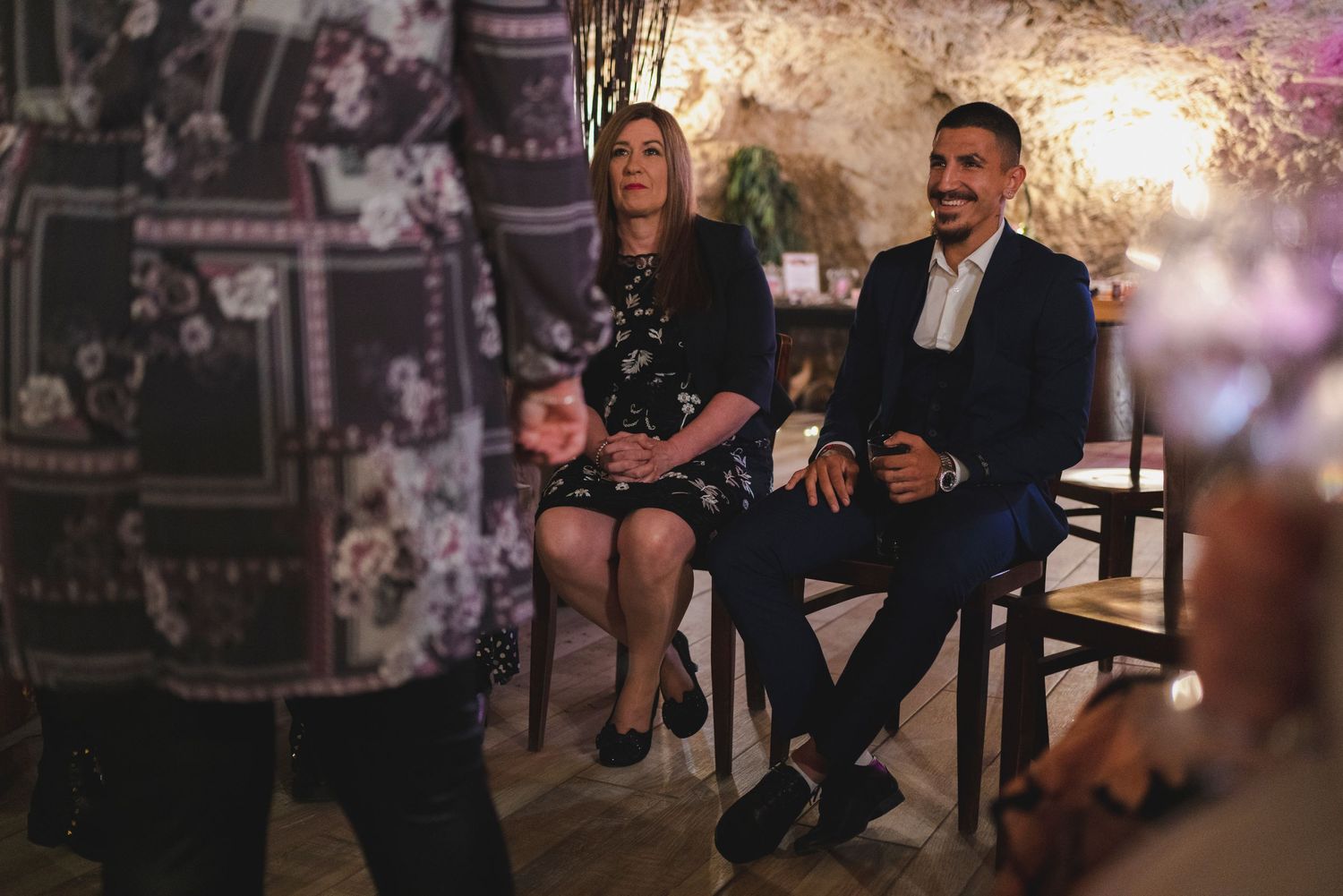 A dimly lit indoor venue with couples seated in a cozy atmospheric setting.