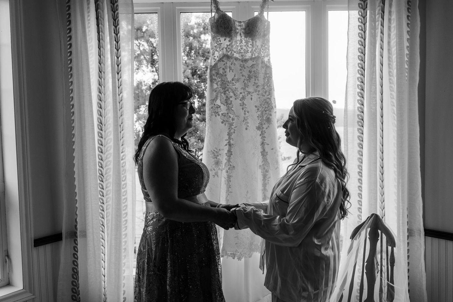 Black and white collage of figures in silhouette standing near windows with curtains and drapes in natural light.
