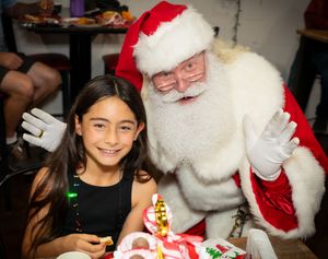 Children visiting with Santa Claus at a Christmas celebration event.