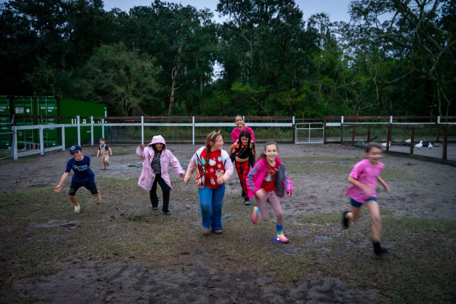 Group playing soccer on outdoor field at twilight.