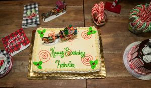 Birthday cakes with candy cane decorations and festive holiday themes on wooden table.