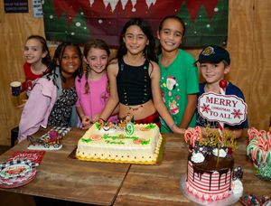 Children's holiday party with decorated cakes and festive Christmas decorations.