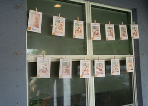 Polaroid-style photos hanging on display line against wall at party.