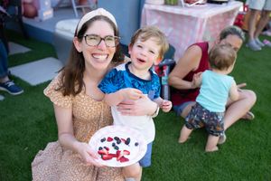 Casual outdoor celebration with guests enjoying festivities on grass.