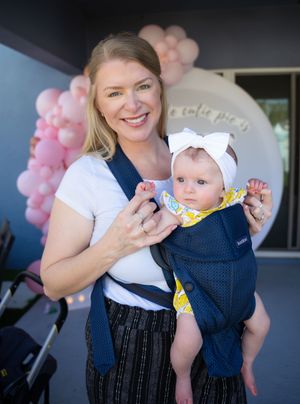 Party scene with navy and white outfits against pink balloon backdrop.