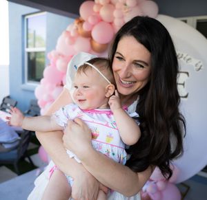 Baby celebration with pink balloon decorations and festive party atmosphere on a porch.