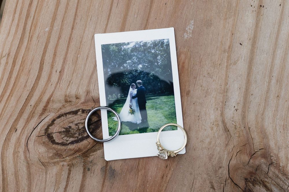 Wedding photographs displayed on a rustic wooden surface with natural grain patterns.