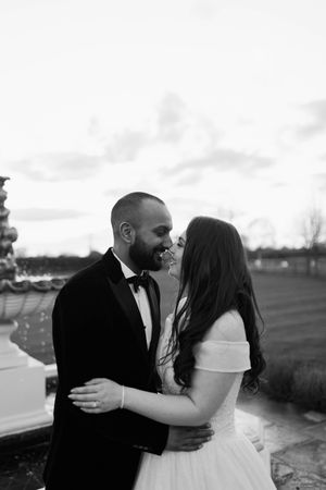 A romantic black and white photo series showing a couple sharing kisses and embraces outdoors at sunset.