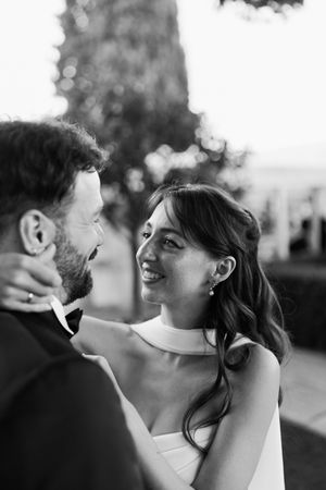 A romantic black and white photo shows a couple sharing a tender moment outdoors.
