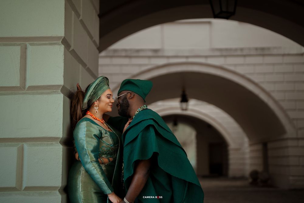 Woman in traditional green attire dances elegantly between classical archways.