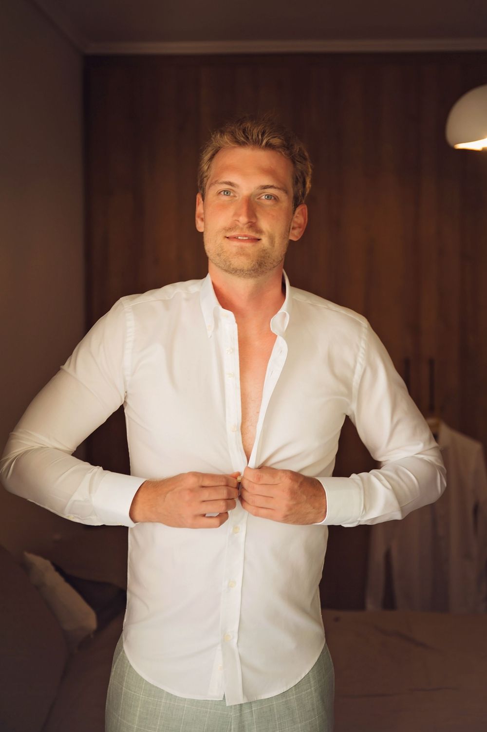 Sequence of photos showing someone getting dressed in a white button-down shirt in a dimly lit room.