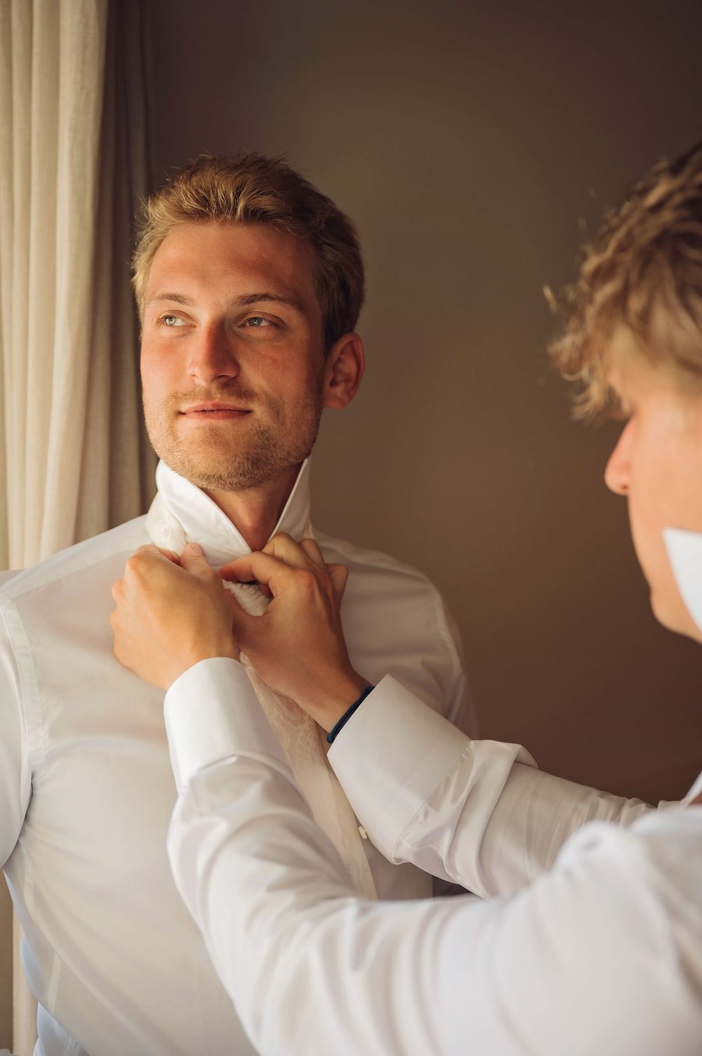 Getting ready scene shows groom's morning preparations in soft natural light.