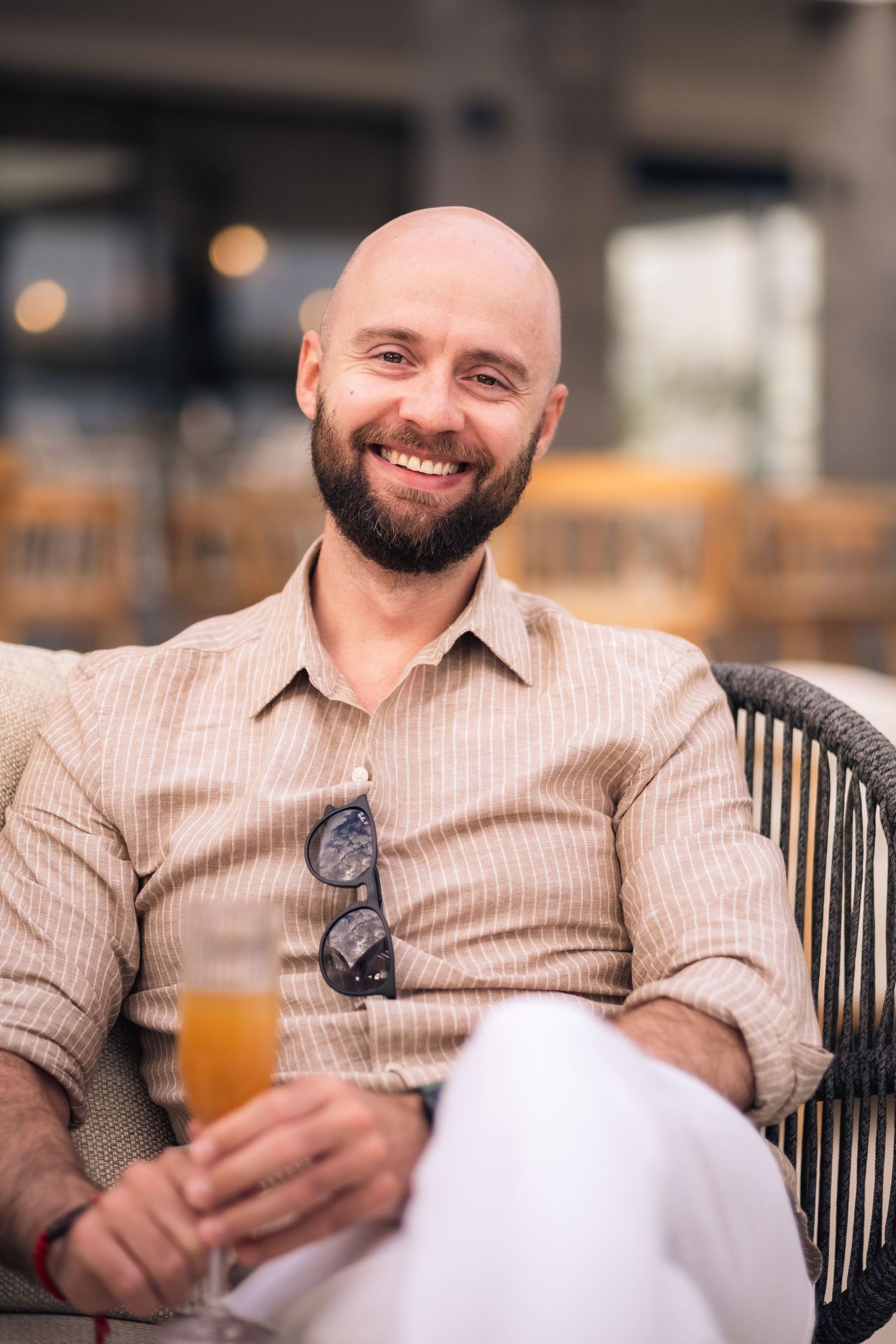 Person enjoying a refreshing beverage while relaxing in casual attire.