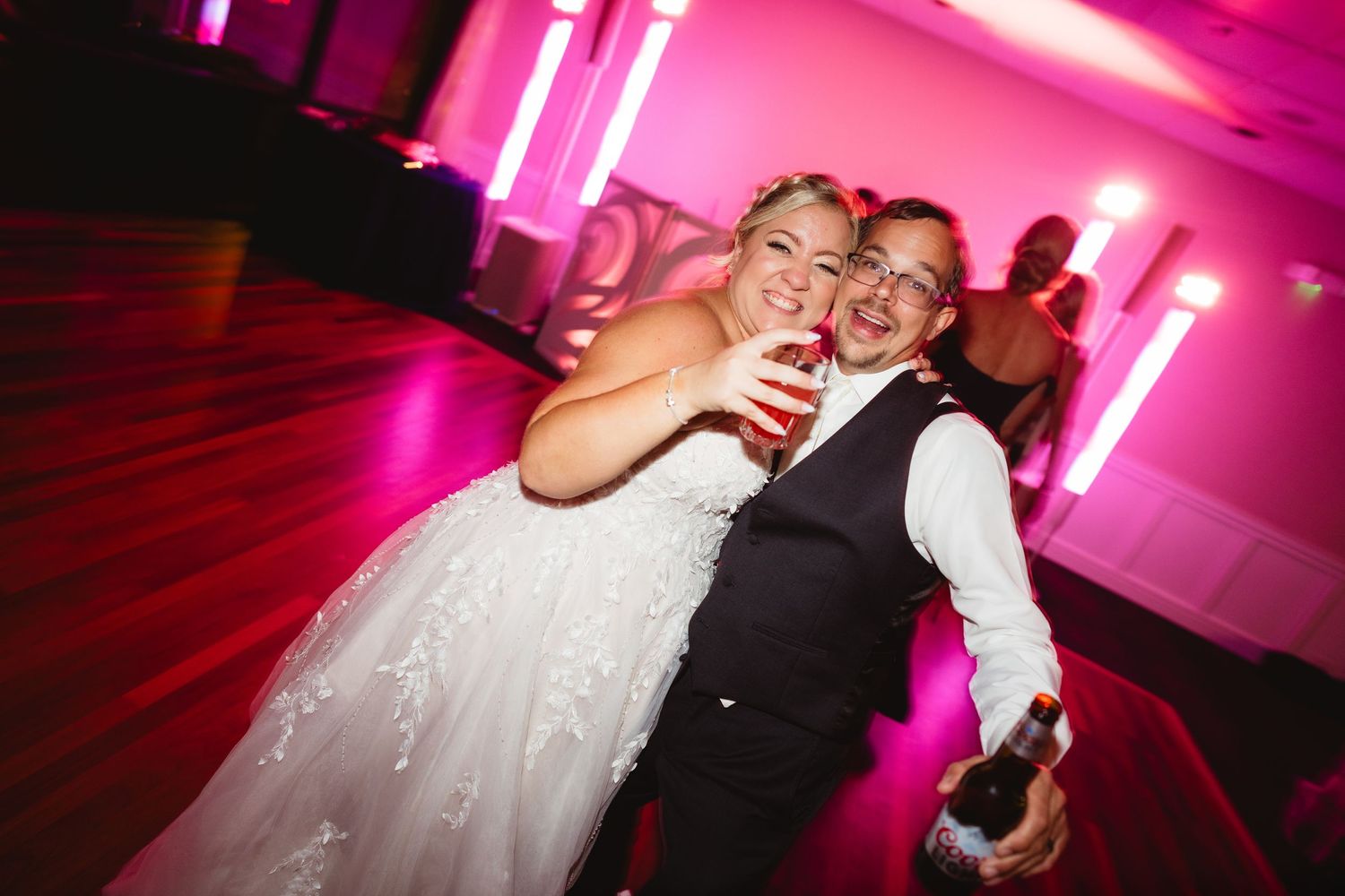 Wedding reception photos showing dancing couples under dramatic pink and purple lighting effects.