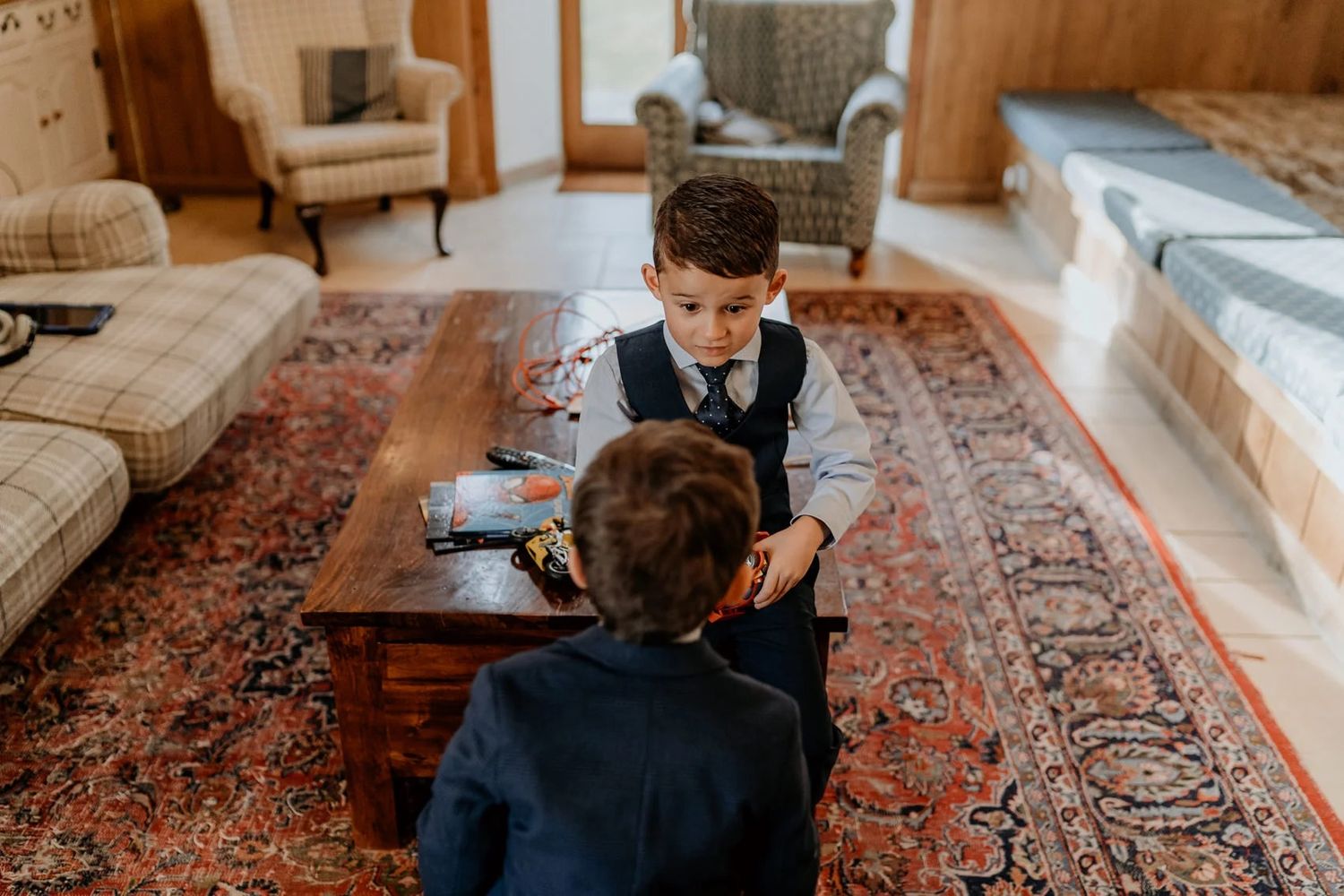 Intimate getting ready scene in a room with oriental rugs and wooden furniture.