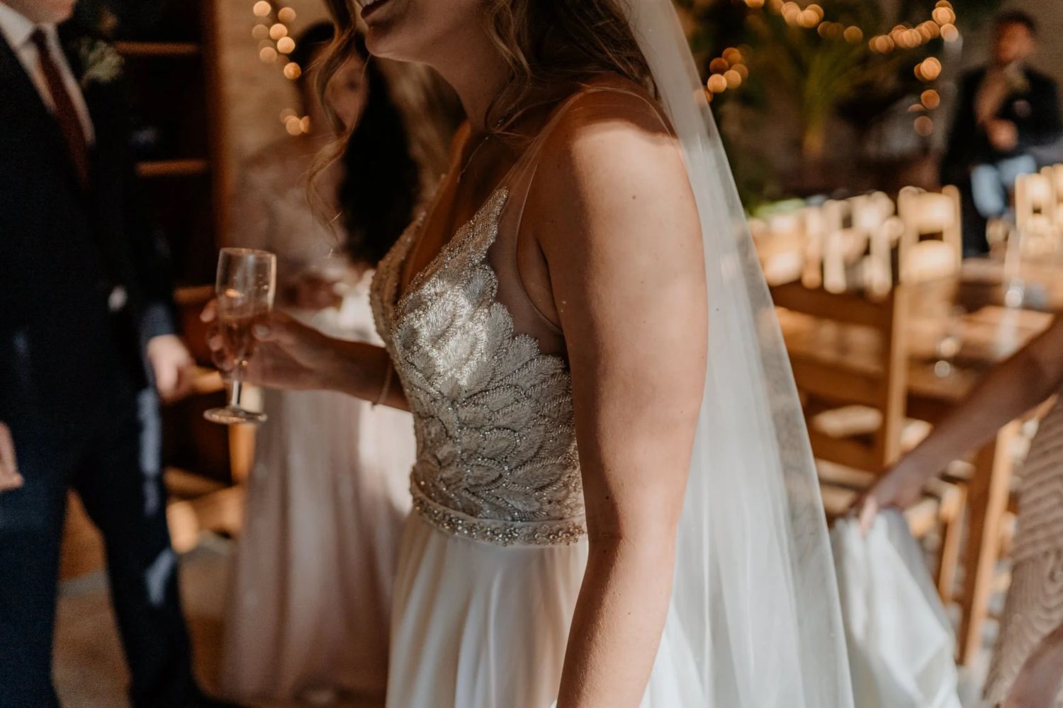 Elegant wedding details featuring white gowns and floral arrangements in a rustic setting.