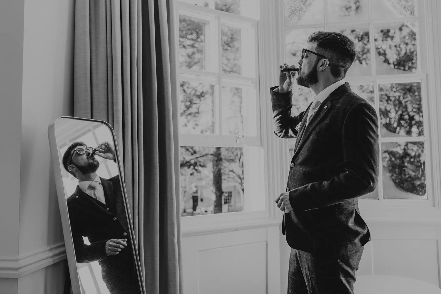 Man adjusts navy blue suit jacket and sleeve cuff in a candid series of detail shots.