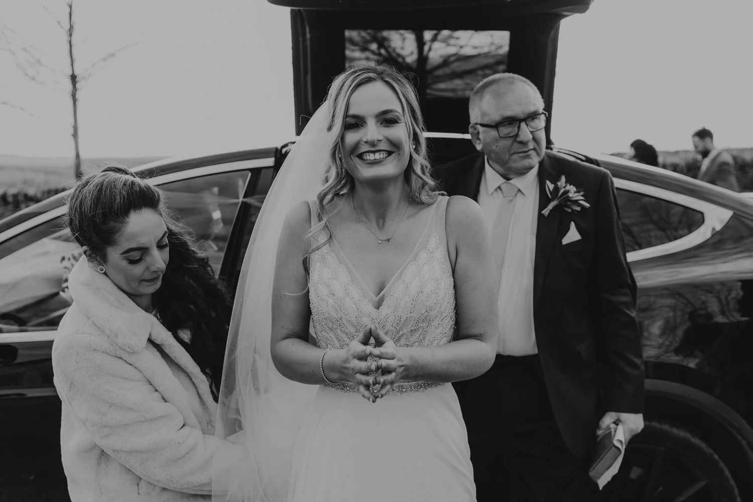 A pair celebrates joyfully in black and white at an outdoor wedding ceremony.
