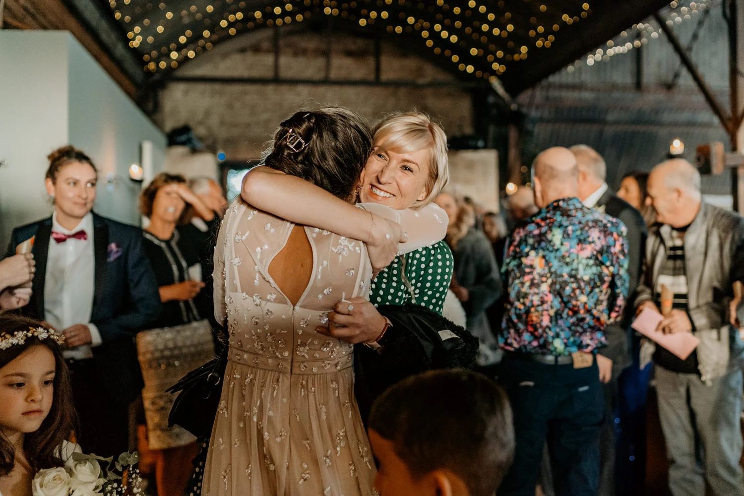 Candlelit wedding reception with guests dancing under twinkling lights.