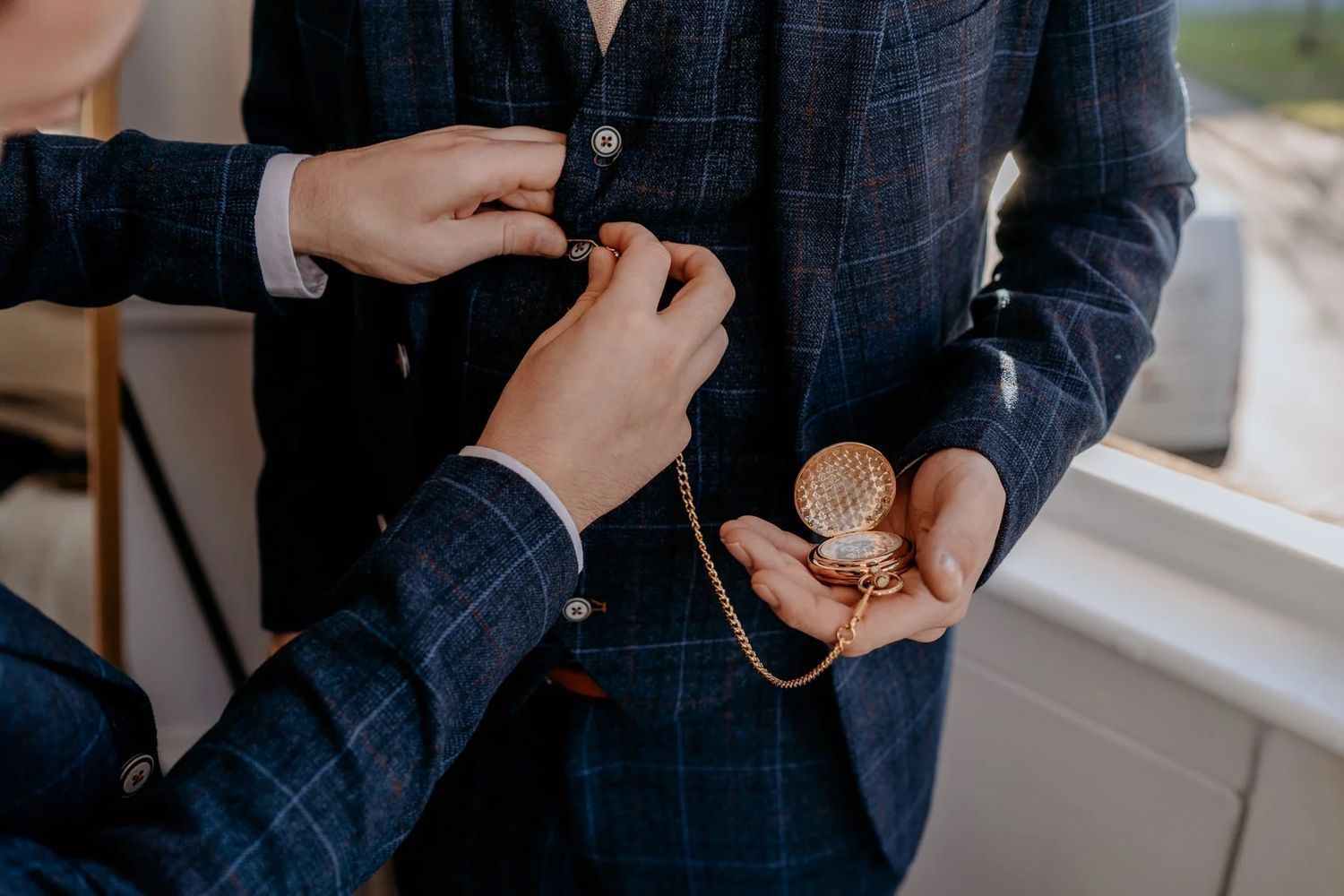 Close up photos of a suit jacket sleeves and cuff buttons being adjusted.