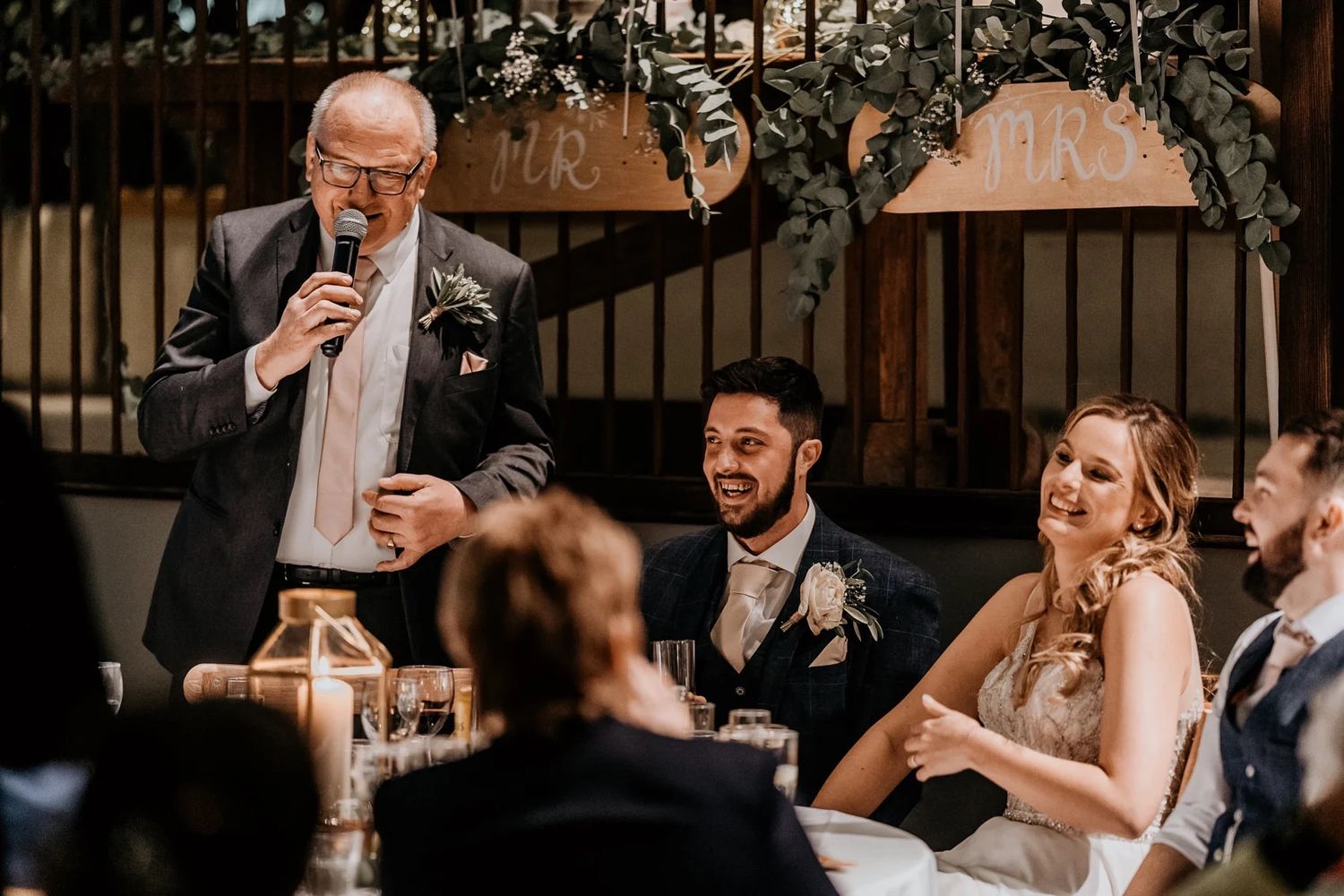 Wedding guests enjoying drinks and conversation at an indoor reception.